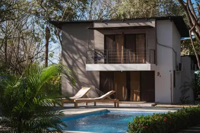 a villa with a swimming pool and a house at Blue Window Boutique Villas Hotel in Playa Junquillal