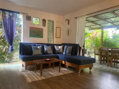 a living room with a blue couch and a table at The Lizard in Santa Teresa Beach