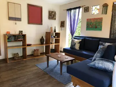 a living room with a blue couch and a table at The Lizard in Santa Teresa Beach