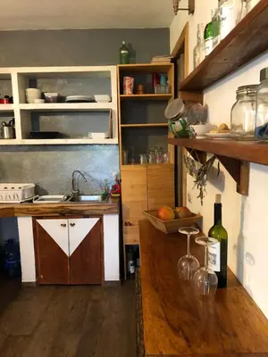 a kitchen with a sink and a counter with wine bottles at The Lizard in Santa Teresa Beach