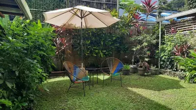 a table and two chairs under an umbrella at The Lizard in Santa Teresa Beach