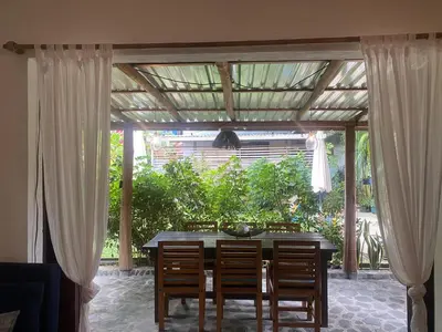 a dining room table with chairs and a pergola at The Lizard in Santa Teresa Beach