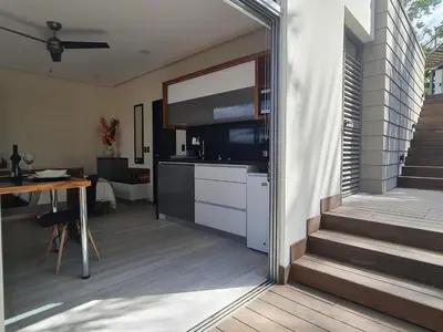 a kitchen with a television and a table and stairs at Cute Escazú Loft -Great view- in Escazu