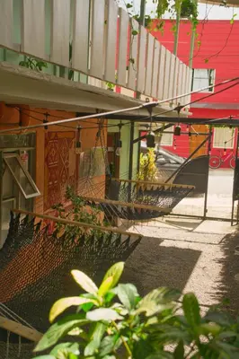 a hammock on the side of a building at Alpha Arenal Hostel in Fortuna