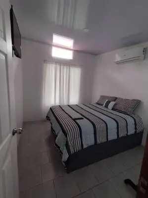 a bedroom with a bed in a white room at Tiny house PZ in San Rafael Norte