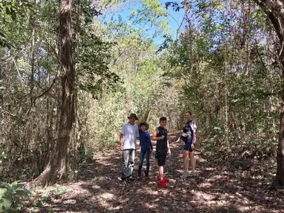a group of people standing on a trail in the woods at Nicoya Silvestre in Lepanto