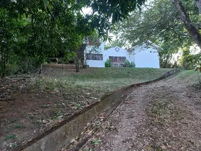a white house in the middle of a yard at Casa Montañas Nicoyanas in Juan Díaz