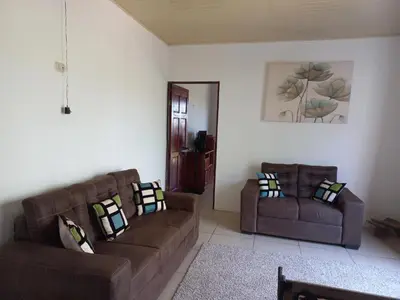 a living room with two brown couches and a mirror at Casa Montañas Nicoyanas in Juan Díaz