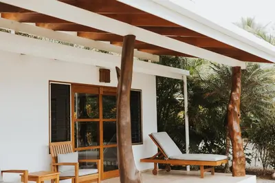 a patio with two chairs and a table at Salvatierra Beachfront Hotel in Puerto Coyote