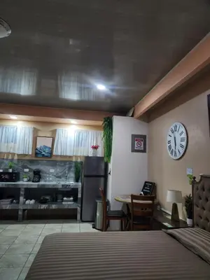 a room with a clock on the wall and a table at Arenal Memories. in Fortuna