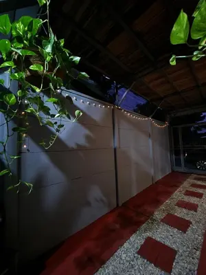a fence with a string of lights on it at Arenal Memories. in Fortuna