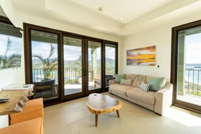 a living room with a couch and a table at 360 Splendor 104B-Ocean View Condo-Breakfast in Playa Flamingo