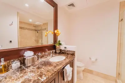 a bathroom with a sink and a mirror and a toilet at 360 Splendor 104F Ocean View 3Br Breakfast in Playa Flamingo