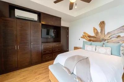 a bedroom with a large bed and a tv at 360 Splendor 104F Ocean View 3Br Breakfast in Playa Flamingo
