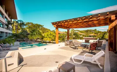 a patio with a table and chairs and a pool at CasaGuana in Playa Hermosa