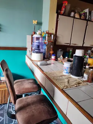 a kitchen with two chairs sitting at a counter at The Cozy Cactus House B&B Cartago Centro English Spoken in Cartago