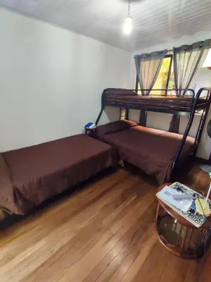a room with two bunk beds and a wooden floor at The Cozy Cactus House B&B Cartago Centro English Spoken in Cartago