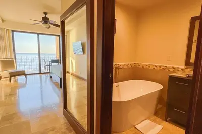a bath tub in a bathroom with a view of the ocean at Seaview Oasis 1-BR Suite in Croc's casino resort in Jacó