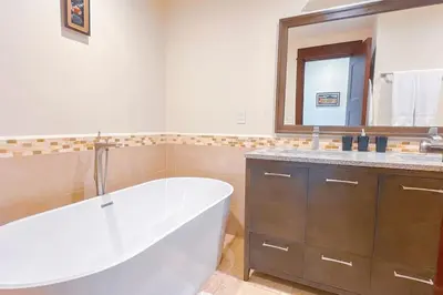 a bathroom with a tub and a sink and a mirror at Seaview Oasis 1-BR Suite in Croc's casino resort in Jacó