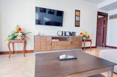 a living room with a flat screen tv on a wall at Seaview Oasis 1-BR Suite in Croc's casino resort in Jacó
