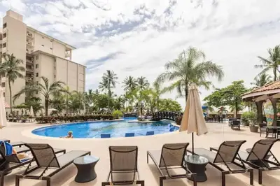 a pool at the resort with chairs and a umbrella at Seaview Oasis 1-BR Suite in Croc's casino resort in Jacó