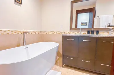 a bathroom with a white tub and a mirror at Seaview Oasis 1-BR Suite in Croc's casino resort in Jacó