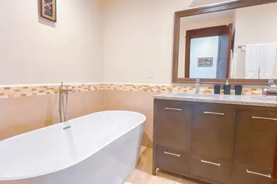 a bathroom with a tub and a sink and a mirror at Seaview Oasis 1-BR Suite in Croc's casino resort in Jacó