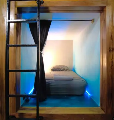 a bedroom with a bunk bed with a ladder at Shipwrecked Hostel in Uvita