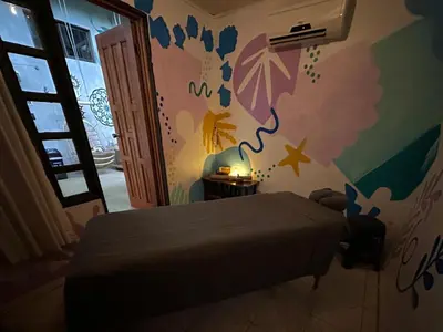 a bedroom with a bed and a wall with umbrellas at Shipwrecked Hostel in Uvita