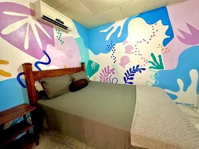 a bedroom with a bed with a fish themed wall at Shipwrecked Hostel in Uvita
