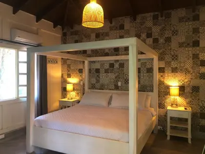 a bedroom with a white canopy bed with two lamps at Hotel Villas Gaia Ecolodge in Uvita