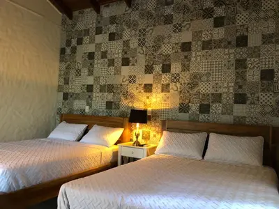 a bedroom with two beds and a wall at Hotel Villas Gaia Ecolodge in Uvita