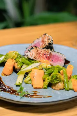 a plate of food with meat and vegetables on a table at Hotel Villas Gaia Ecolodge in Uvita