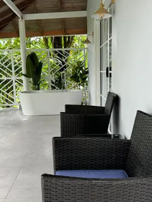two wicker chairs sitting on a porch with a patio at Hotel Villas Gaia Ecolodge in Uvita