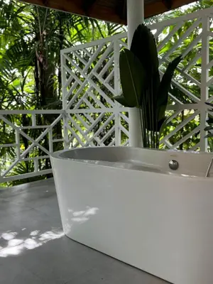 a white bench with a potted plant next to a fence at Hotel Villas Gaia Ecolodge in Uvita