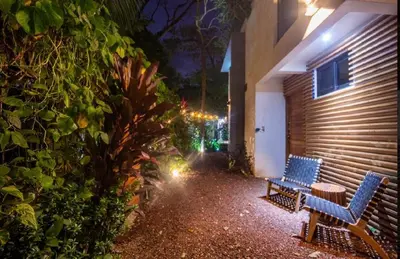 two blue benches sitting next to a building at night at Condo VNV walking distance to the beach in Nosara