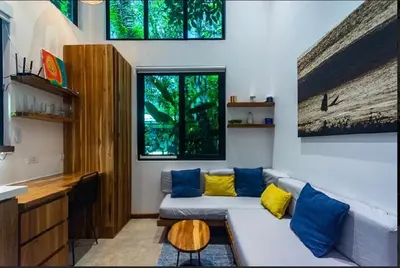 a living room with a couch with yellow and blue pillows at Condo VNV walking distance to the beach in Nosara