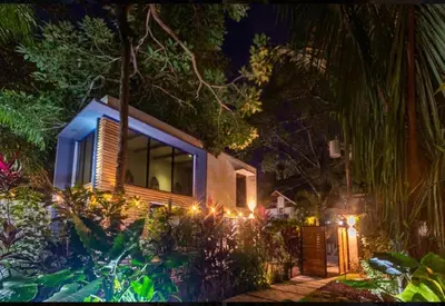 a house with lights in the garden at night at Condo VNV walking distance to the beach in Nosara