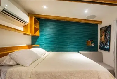 a bedroom with a white bed and a blue wall at Condo VNV walking distance to the beach in Nosara