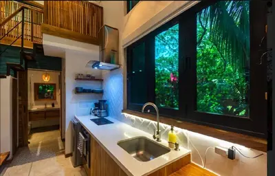 a kitchen with a sink and a large window at Condo VNV walking distance to the beach in Nosara