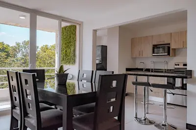 a kitchen and dining room with a table and chairs at Departamento de lujo en la playa in Jacó