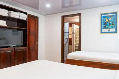 a bedroom with a bed and a flat screen tv at Laguna Eco Village #205 Pool/ Tennis Courts/ BBQ in Quepos