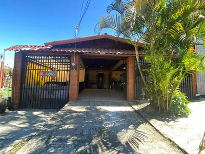 a house with a gate and a palm tree at Casa Lupita Alajuela in Alajuela City