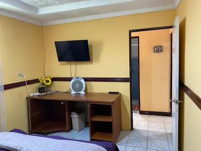 a room with a desk with a television on a wall at Casa Lupita Alajuela in Alajuela City