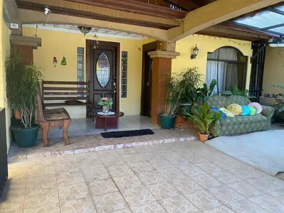 a living room with a couch and some plants at Casa Lupita Alajuela in Alajuela City