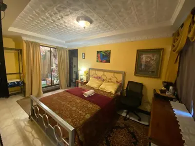 a bedroom with a bed and a chair in it at Casa Lupita Alajuela in Alajuela City