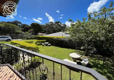 a view of a yard with a fence and a garden at TucanTico Lodge - Monteverde in Monteverde Costa Rica