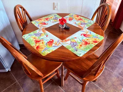 a wooden table with a table cloth on it with two chairs at TucanTico Lodge - Monteverde in Monteverde Costa Rica