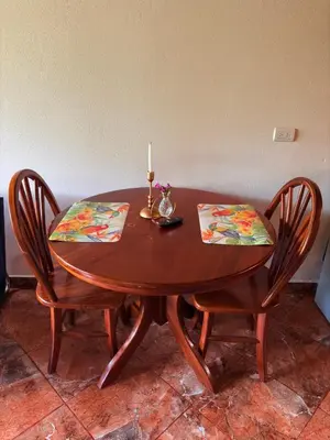 a wooden table with two chairs and a candle on it at TucanTico Lodge - Monteverde in Monteverde Costa Rica