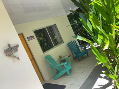 two blue chairs sitting on the porch of a house at Cote Pacific Casitas in Huacas